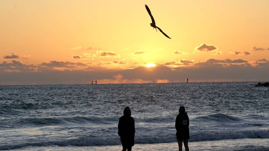 Photo: People watch the sunrise, Tuesday, Nov. 23, 2021, in Miami Beach, Fla....