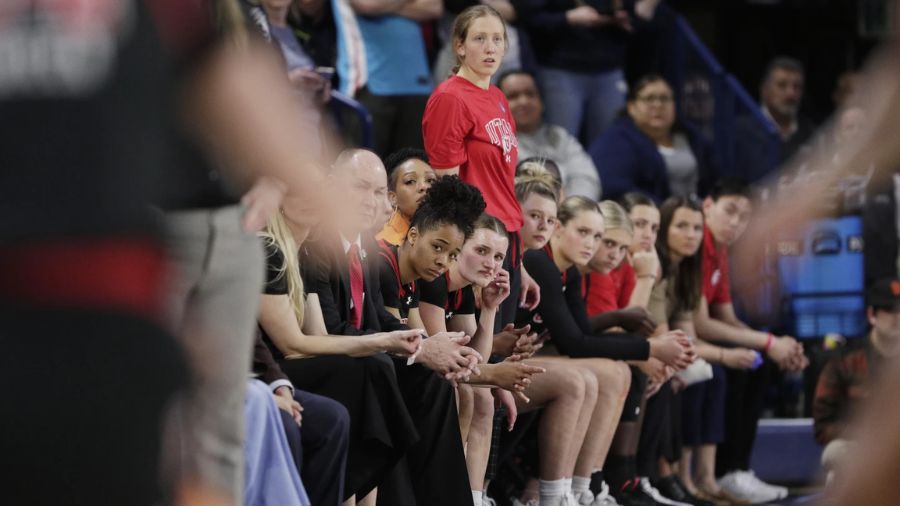 Photo: Players and staff on the Utah bench react toward the end of a second-round college basketbal...
