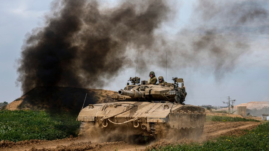 Image: Israeli soldiers drive an tanks on the border with the Gaza Strip, in southern Israel, Tuesd...