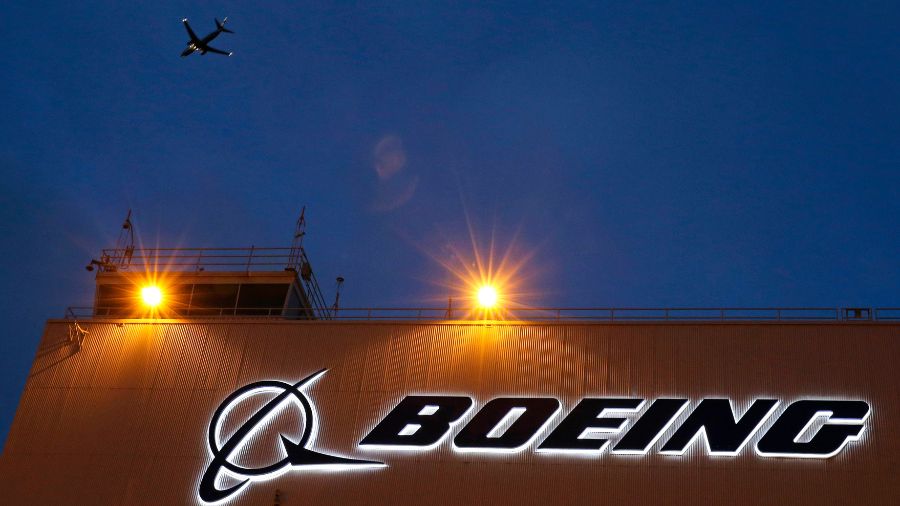 Photo: An airplane flies over a sign on Boeing's newly expanded 737 delivery center, Oct. 19, 2015,...
