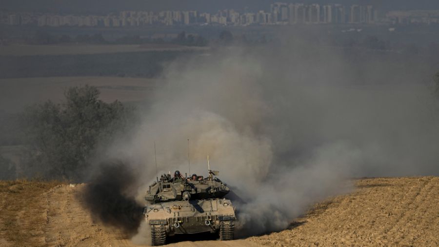 Photo: Israeli soldiers drive a tank near the Israeli-Gaza border, in southern Israel, Wednesday, J...