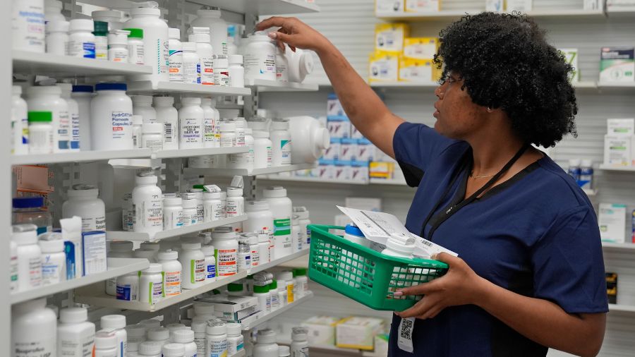 Photo: Lachandretta "LaLa" Williams reaches for a pill bottle at MAC Pharmacy, Wednesday, May 29, 2...
