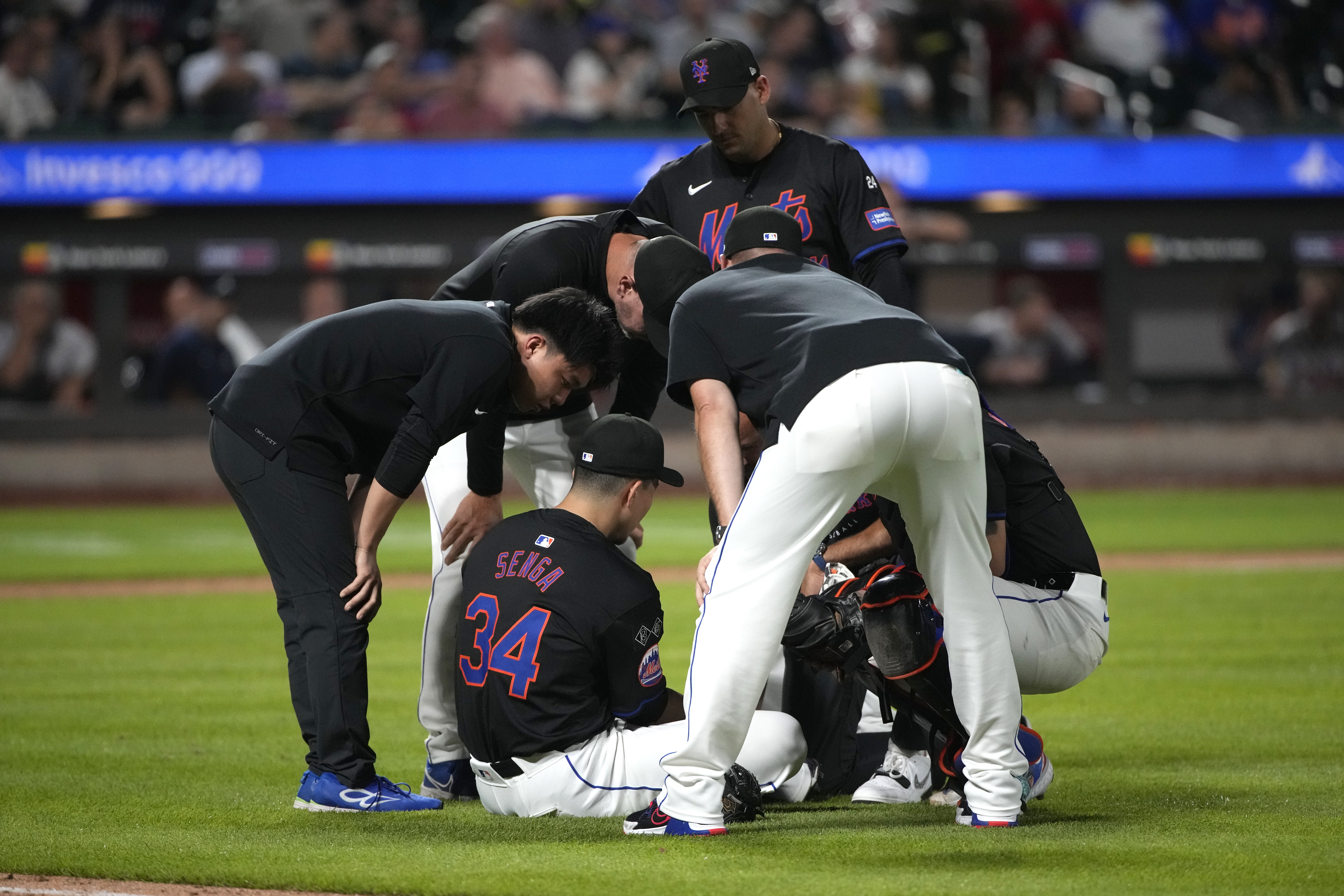 New York Mets staff members check pitcher Kodai Senga (34) after he was injured during the sixth in...