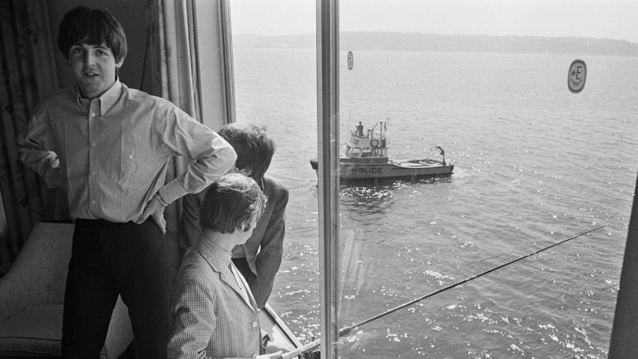 Image: Paul McCartney, George Harrison and Ringo Starr of The Beatles fishing from their hotel room...