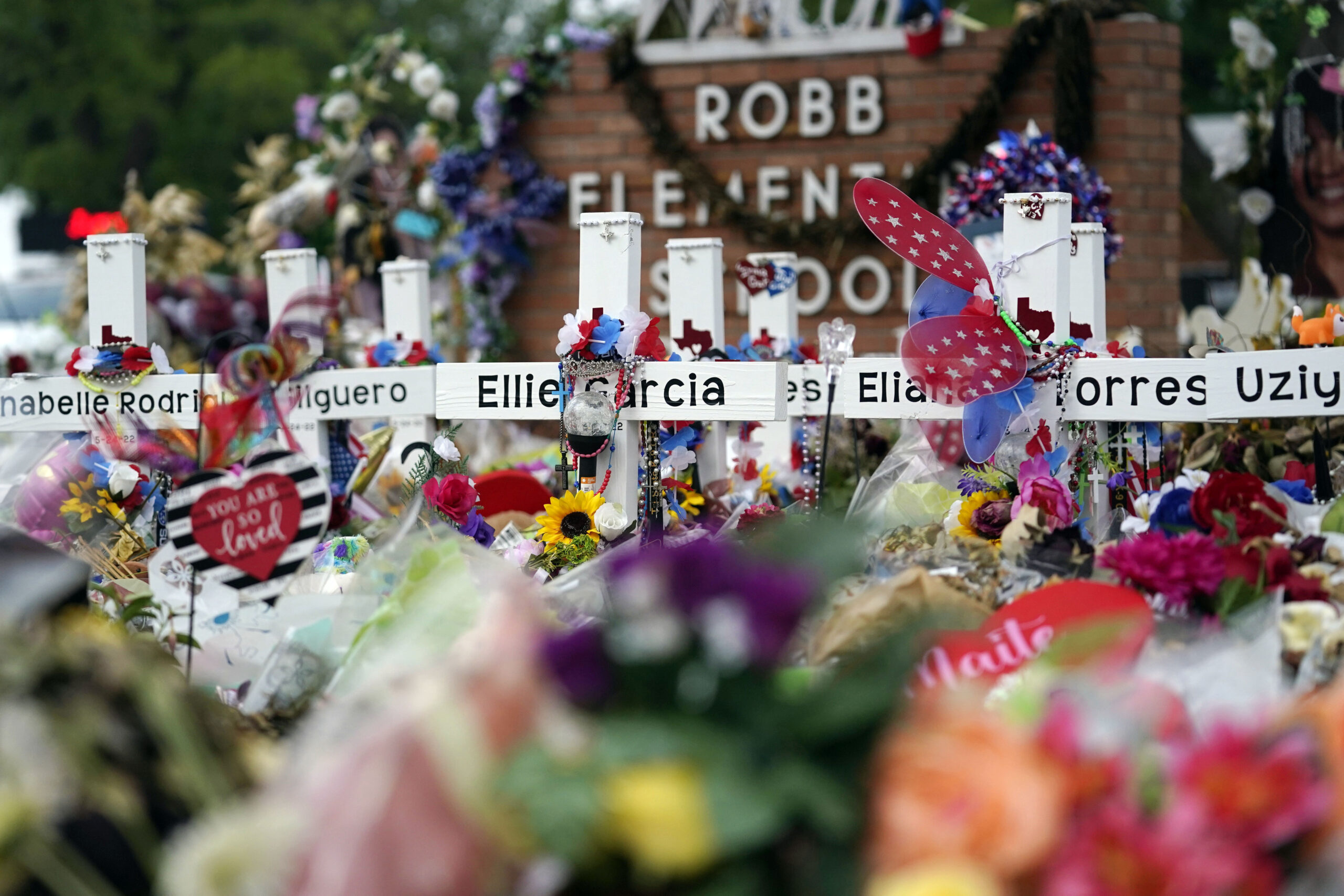 FILE - Flowers and other items surround crosses at a memorial, June 9, 2022, for the victims of a s...