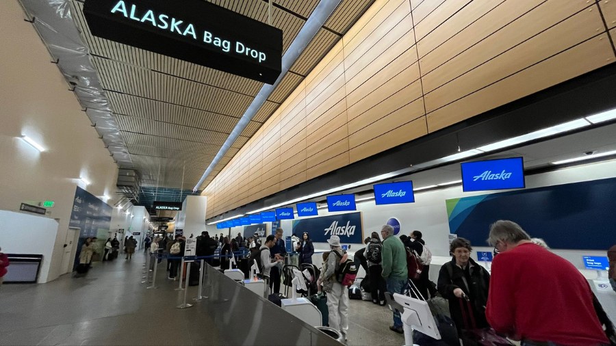 Image: People stand inside of Seattle-Tacoma International Airport....