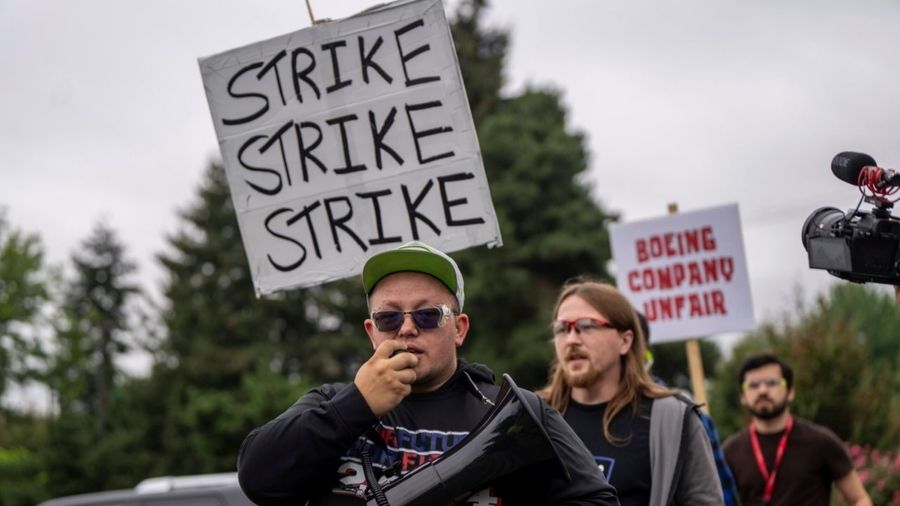 Photo: International Aerospace Machinists union members march toward the union's hall to vote on a ...