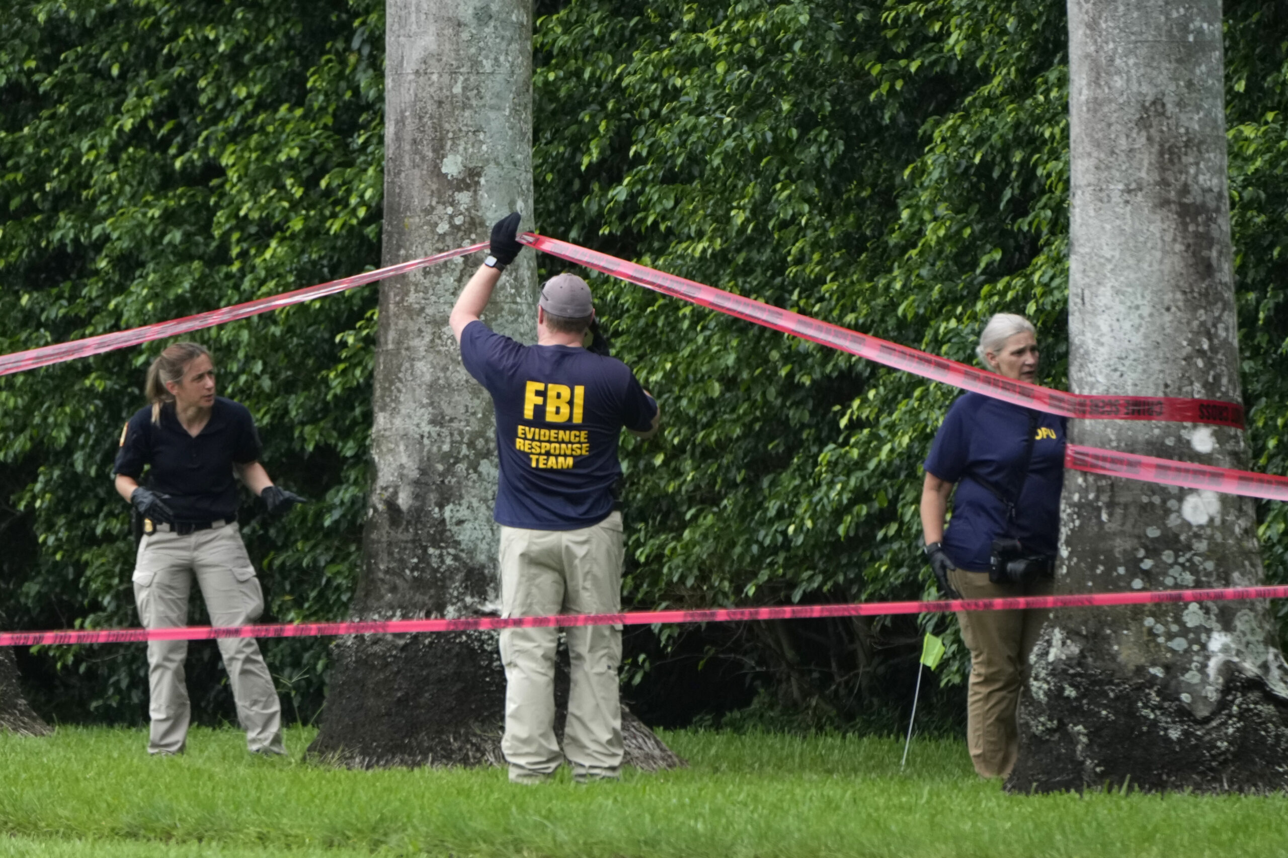 Law enforcement officials work at the scene of the Trump International Golf Club in the aftermath o...