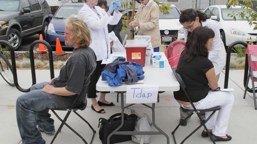 Photo: People wait to receive a Tdap vaccination....