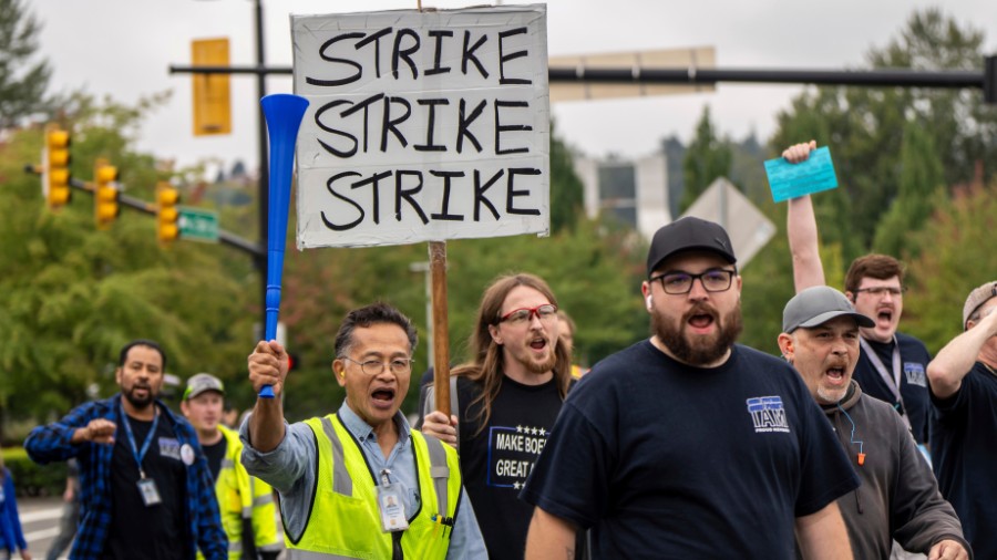 Image: International Aerospace Machinists union members march toward the union's hall to vote on a ...