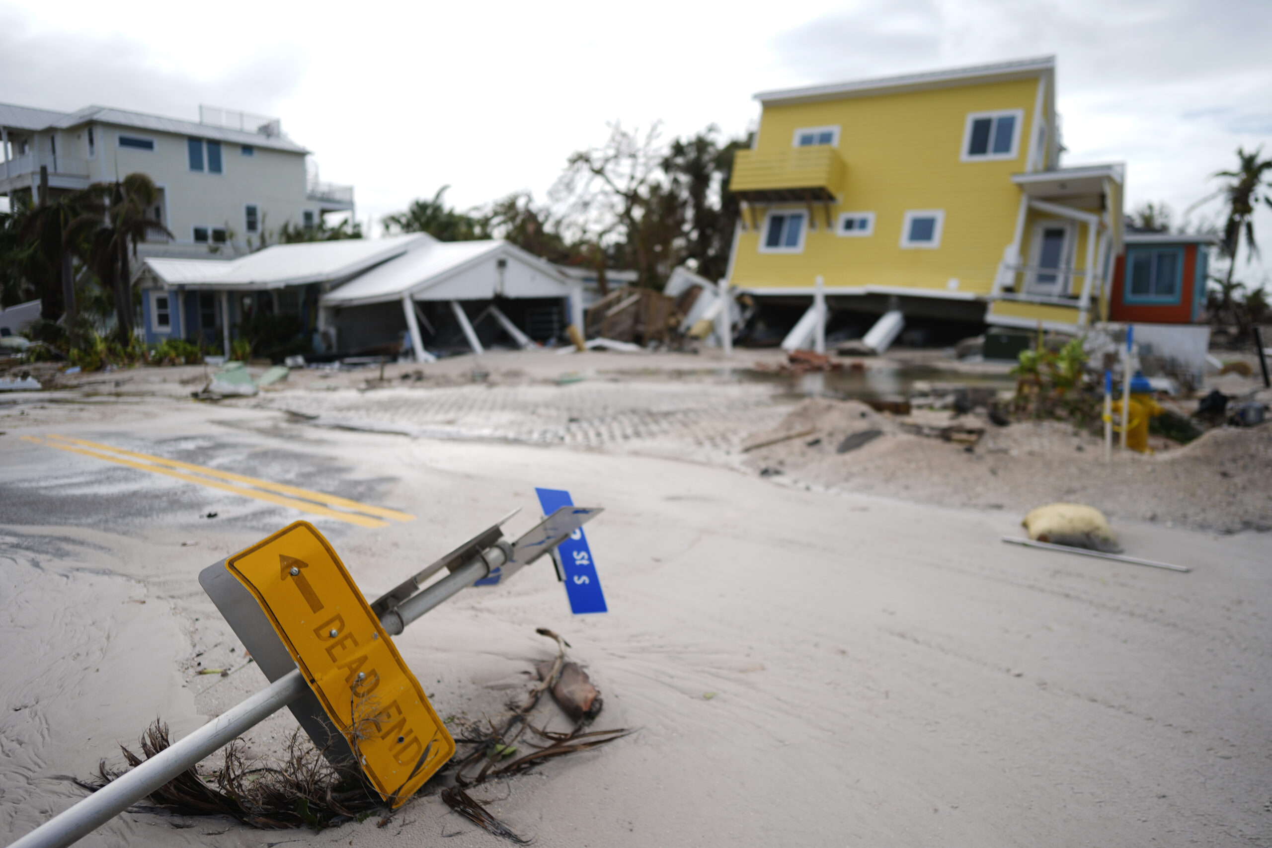 A house sits toppled off its stilts after the passage of Hurricane Milton, alongside an empty lot w...