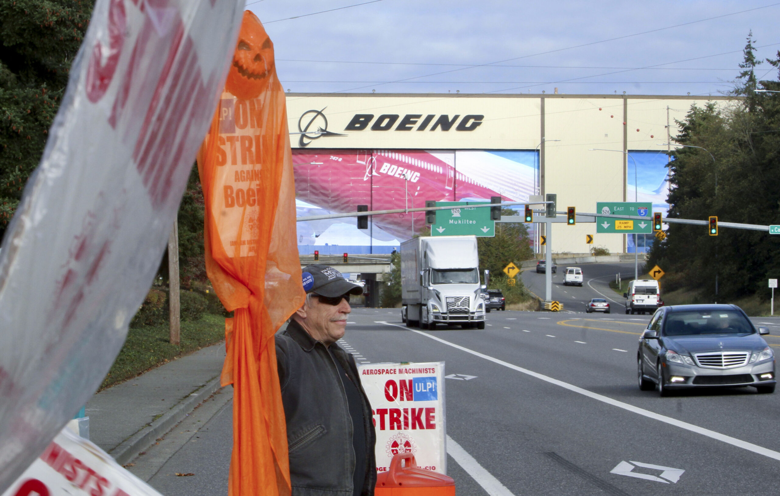 Union machinist Terry Muriekes waves a Halloween-decorated strike sign by Boeing's Everett, Wash., ...