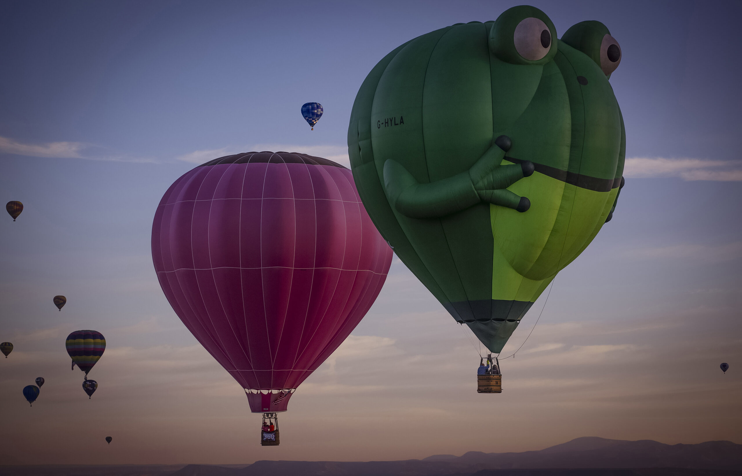 Balloons sail in the sky captured during flight in Meow Wolf's Skyworm hot air balloon during the A...