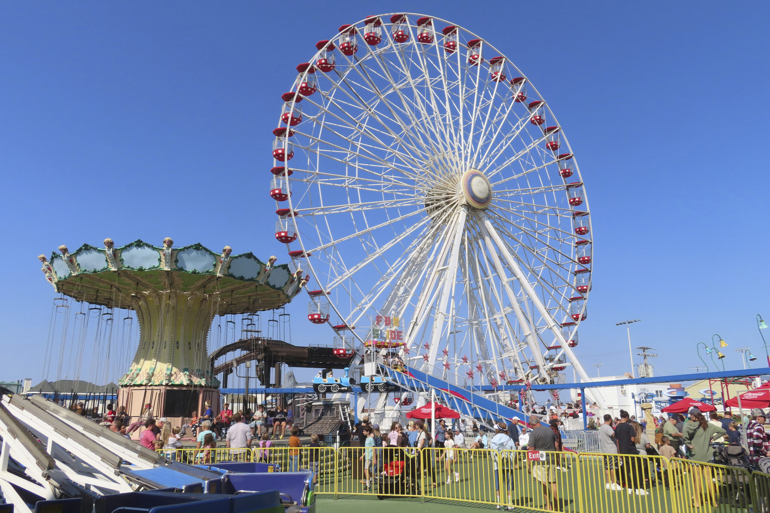 People ride the Giant Wheel and flying chair ride at Gillian's Wonderland, the popular amusement pa...