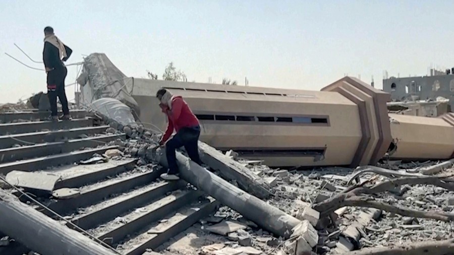 Image: People observe a mosque destroyed by Israeli airstrikes in the city of Khan Younis in the so...