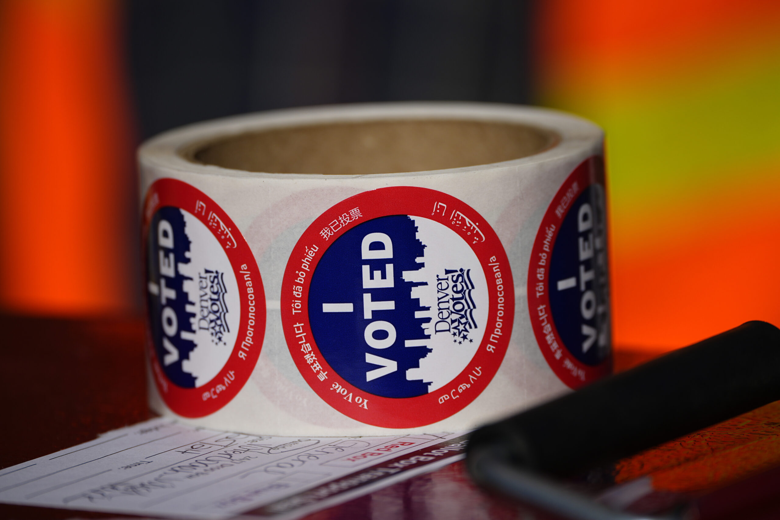 FILE - Stickers for voters sit in a roll on top of a ballot box at a voting drop-off location, Oct....