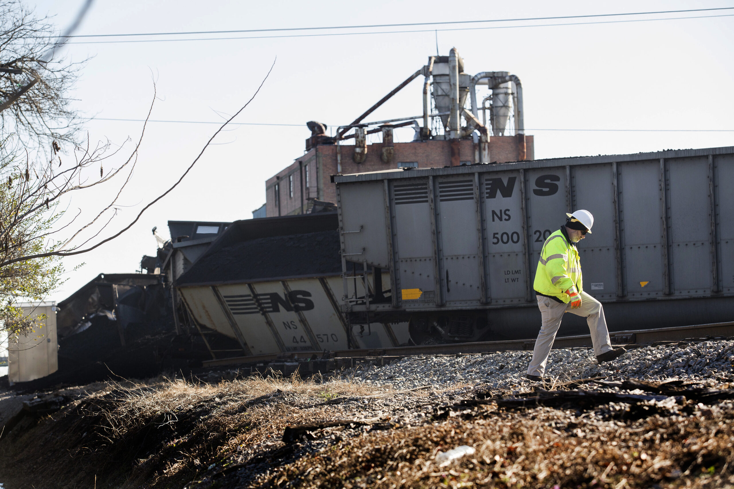 FILE - A Norfolk Southern worker walks next to the scene of a multi-car coal train derailment near ...