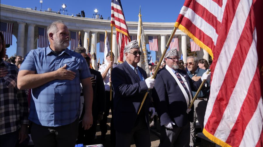 Photo: Attendees look on during the Presentation of the Colors at the National Veterans Day Observa...