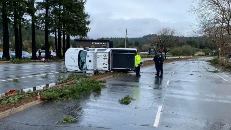 Police officers check on the damage to this vehicle from an EF1 tornado that touched down in Scotts...