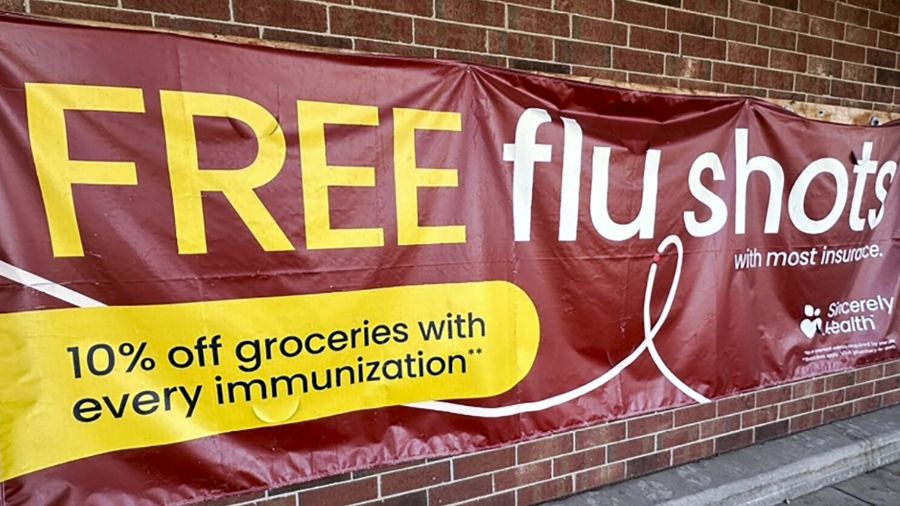 Photo: A sign for flu vaccination is displayed outside of a grocery store, Thursday, Feb. 15, 2024....