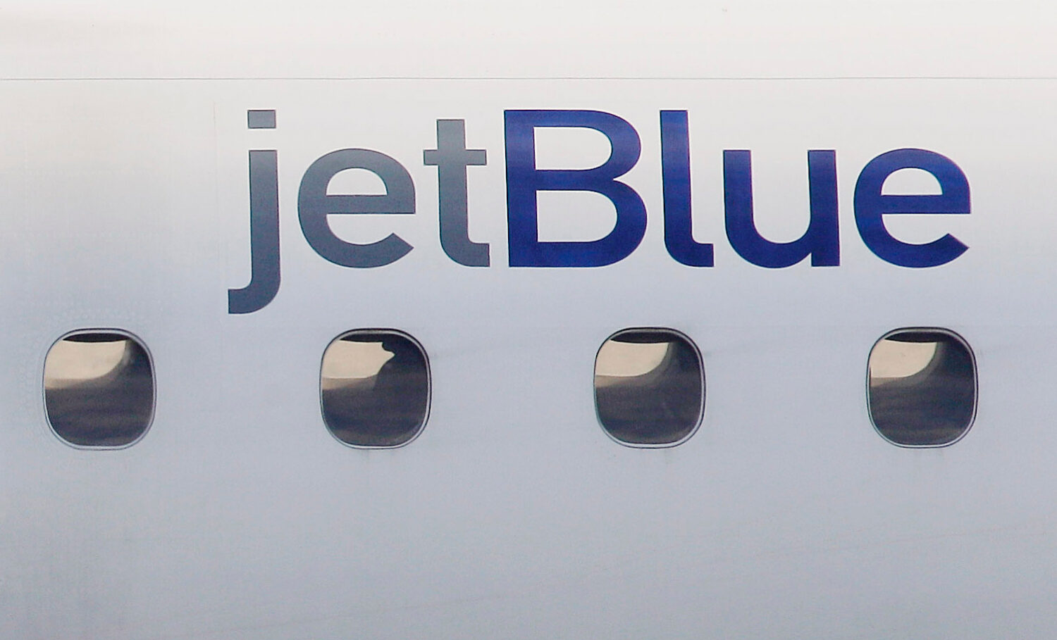 FILE - A JetBlue logo is displayed on the side of a jet as it taxis at Boston's Logan International...