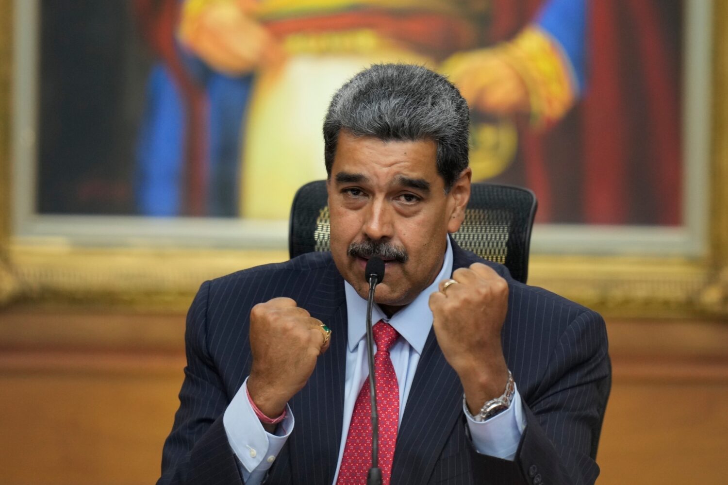 FILE - Venezuelan President Nicolas Maduro raises up his closed fists during a news conference at M...