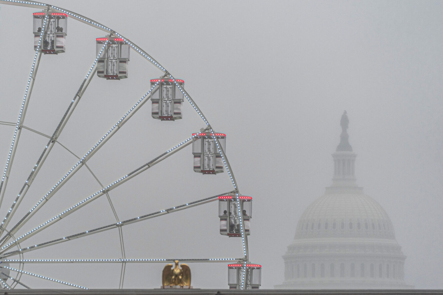 The U.S. Capitol is seen through fog behind the ferris wheel at the Great American State Fair on th...