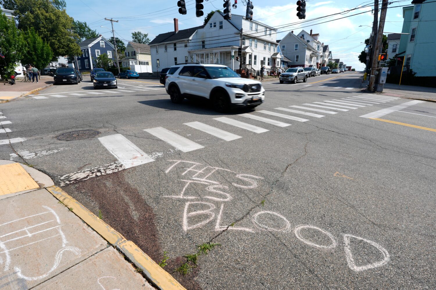 Blood is seen on the pavement near the scene of a shooting involving U.S. Immigration and Customs E...