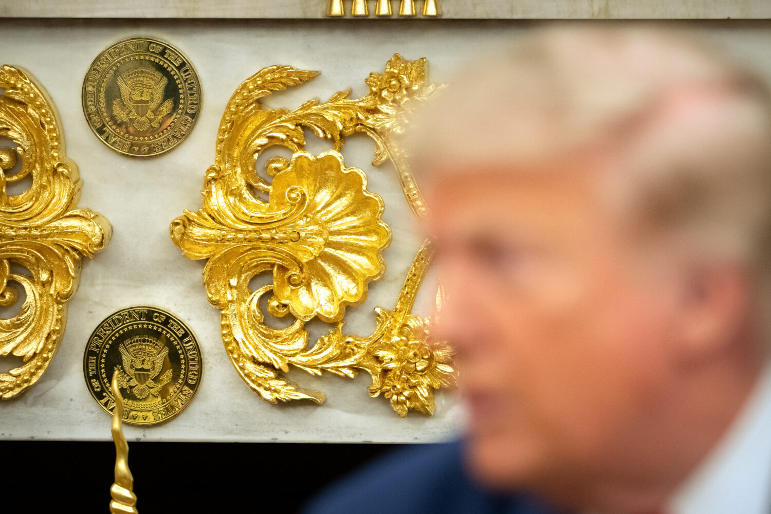 Gold-colored Presidential seals are seen on a fireplace in the Oval Office as President Donald Trum...