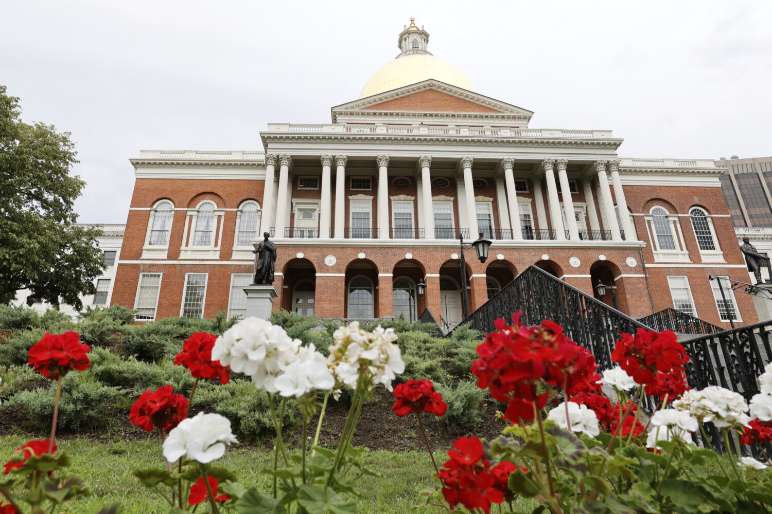 FILE - Flowers adorn the lawn in front of the Massachusetts State House, July 24, 2024, in Boston. ...