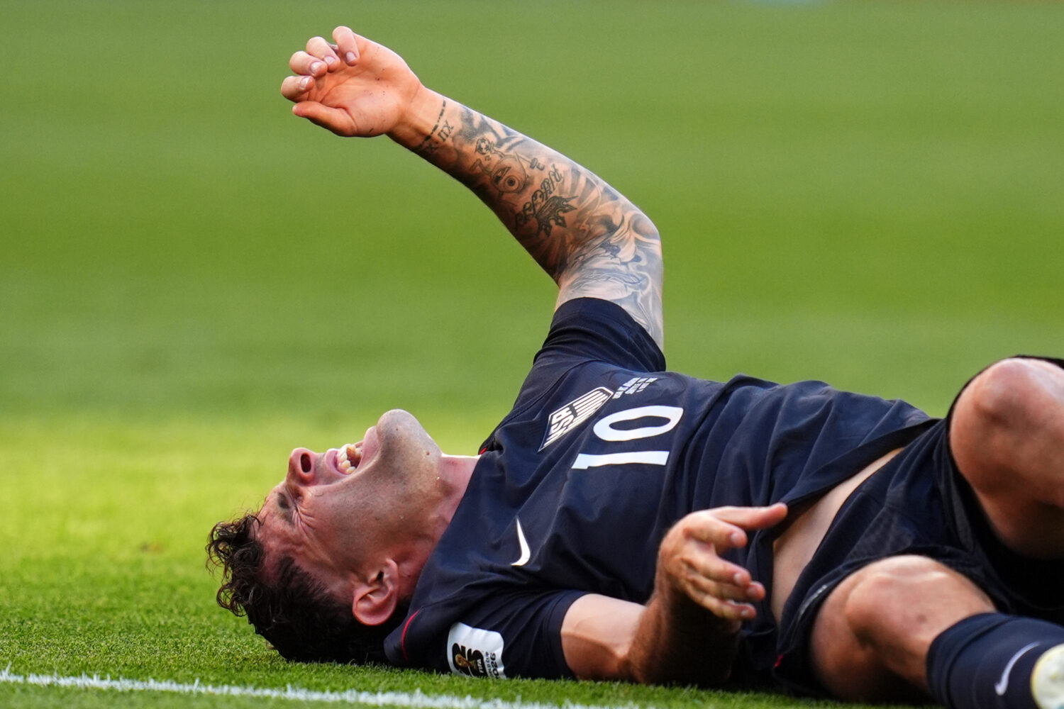 United States' Christian Pulisic (10) reacts after a challenge during the World Cup round of 16 soc...