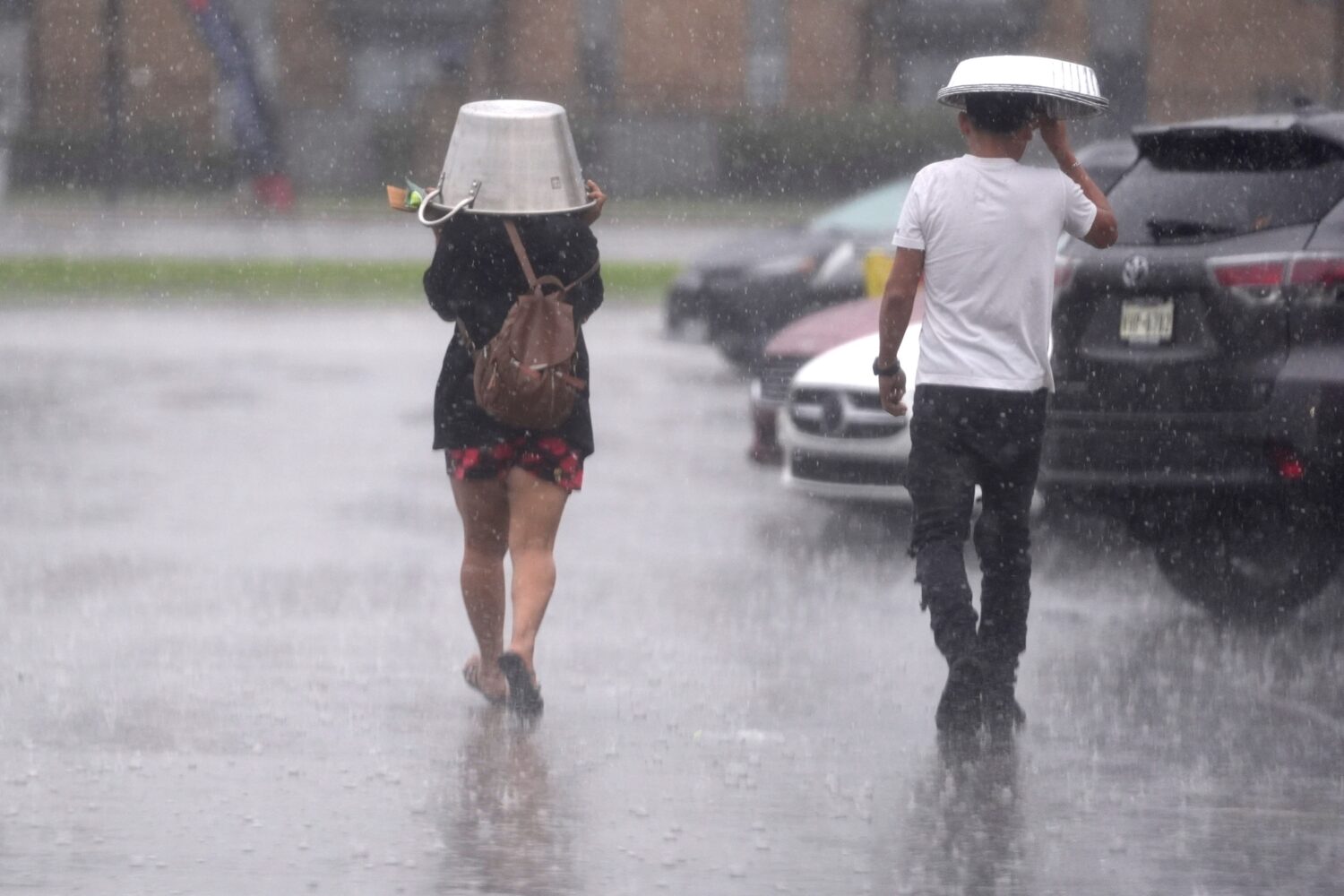 FILE - People cover up from falling rain Dec. 24, 2024, in Dallas. (AP Photo/LM Otero, File)Credit:...
