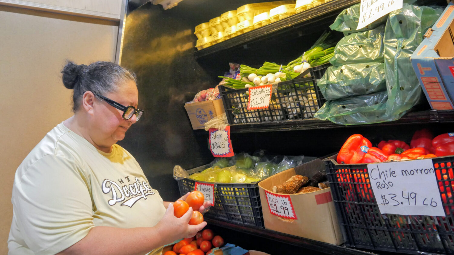 Ada Torres holds tomatoes while shopping for produce, Thursday, July 2, 2026, in Cleveland, Texas, ...