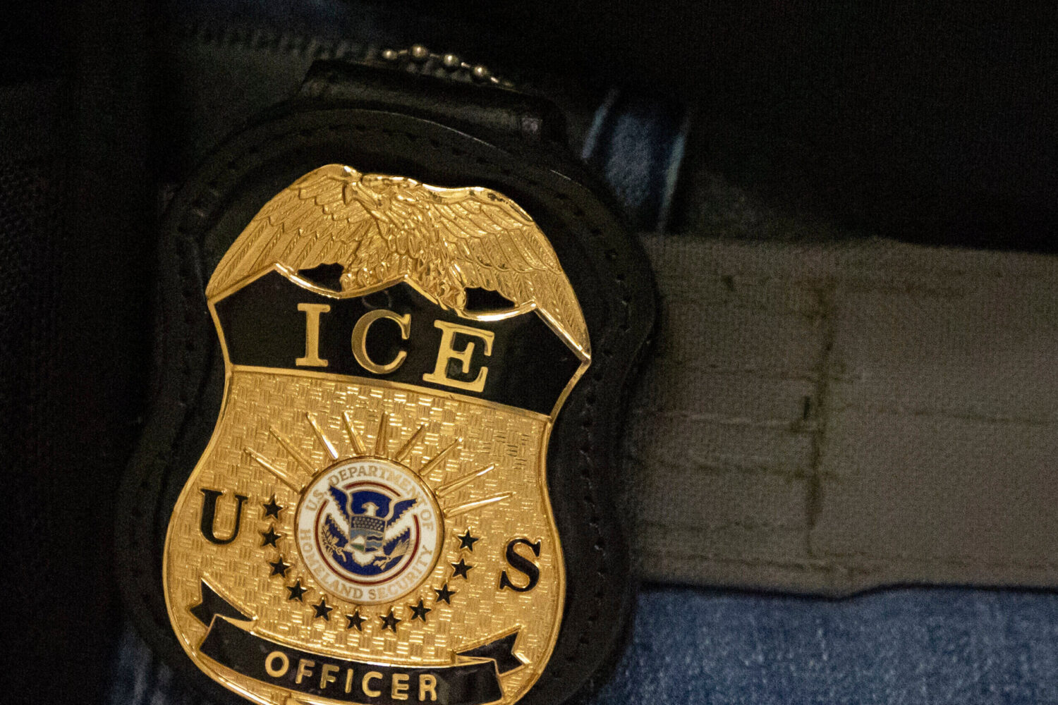 FILE - A federal agent wears an Immigration and Customs Enforcement badge in New York, June 10, 202...