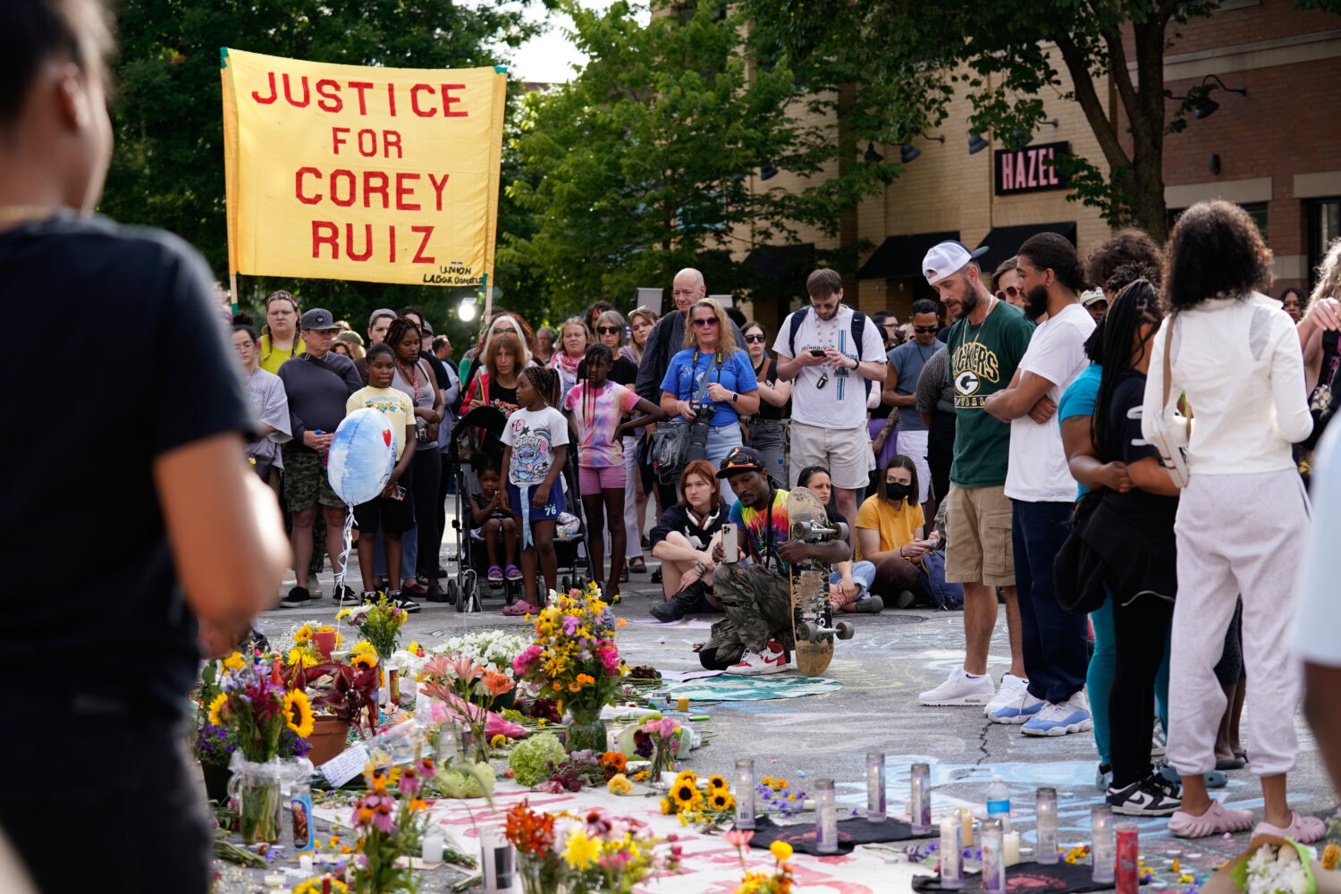 People gather near a memorial at the site where a man was shot and killed on Wednesday by Madison p...