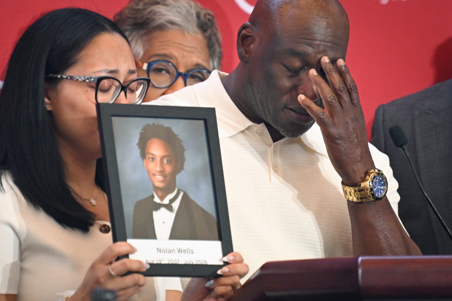 Elmore Wonsley, right, pauses from speaking as wife Christine Wonsley holds a photo of her deceased...