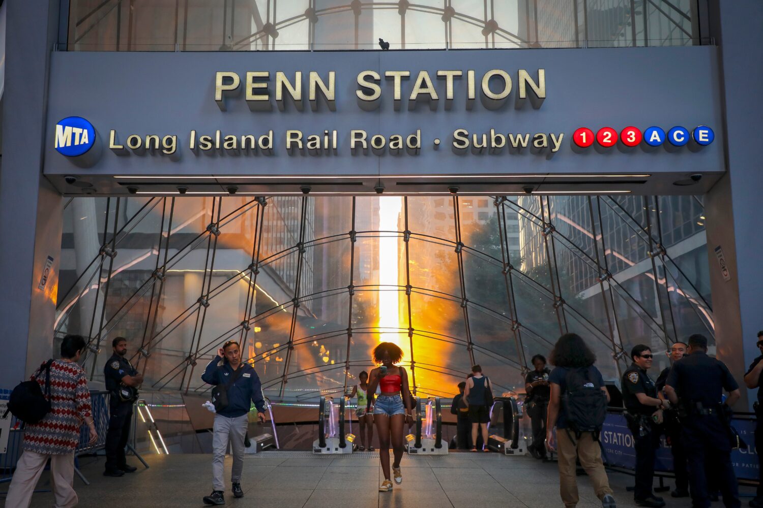 FILE - Commuters pass Penn Station and Madison Square Garden, July 2, 2026, in New York. (Photo by ...