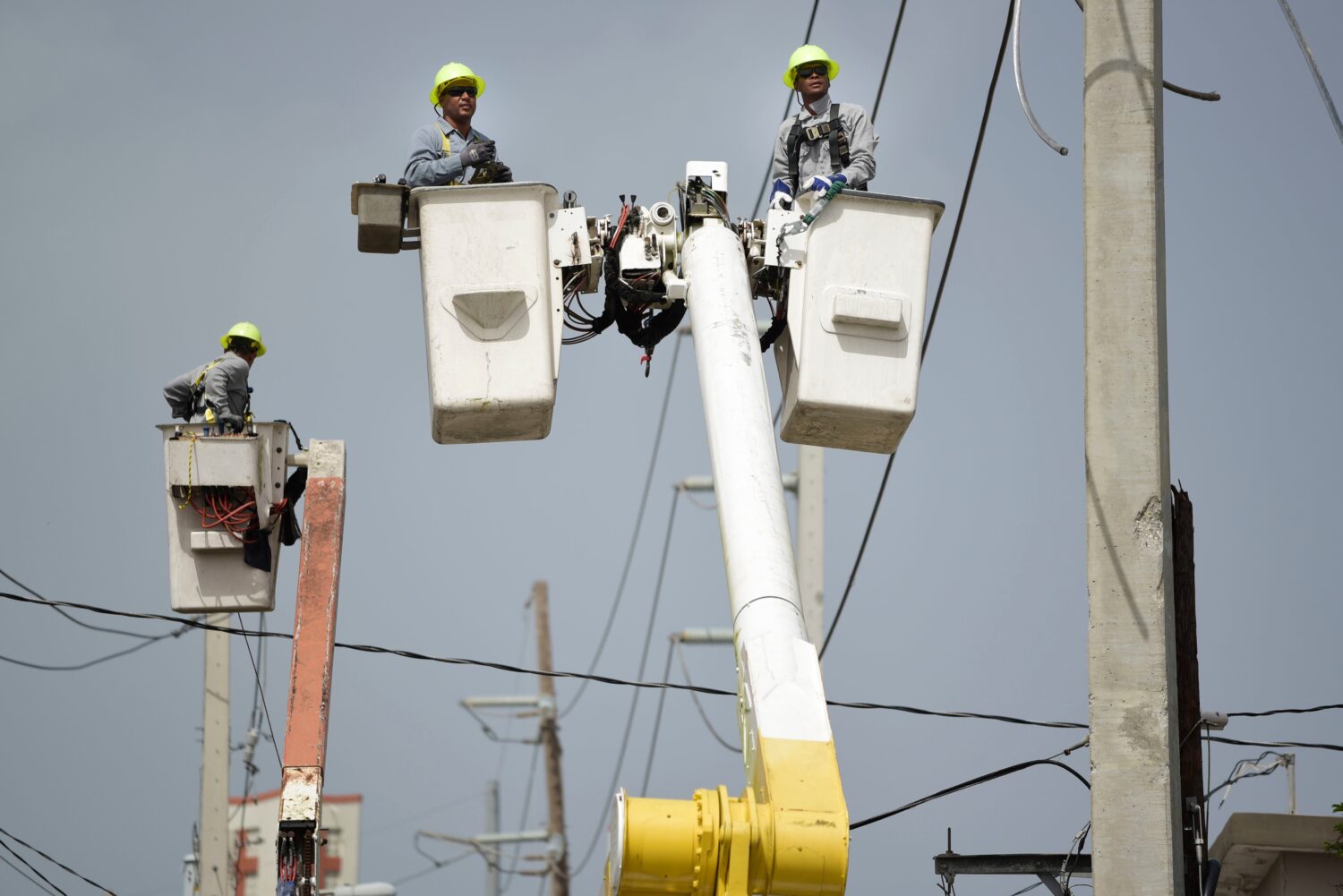 FILE - Puerto Rico Electric Power Authority workers repair distribution lines damaged by Hurricane ...