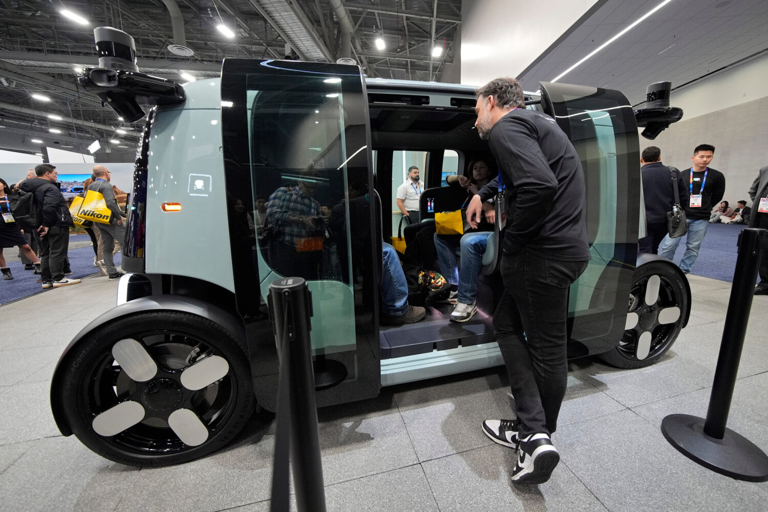 FILE - People view a Zoox self-driving vehicle at the company's booth during the CES tech show, Jan...