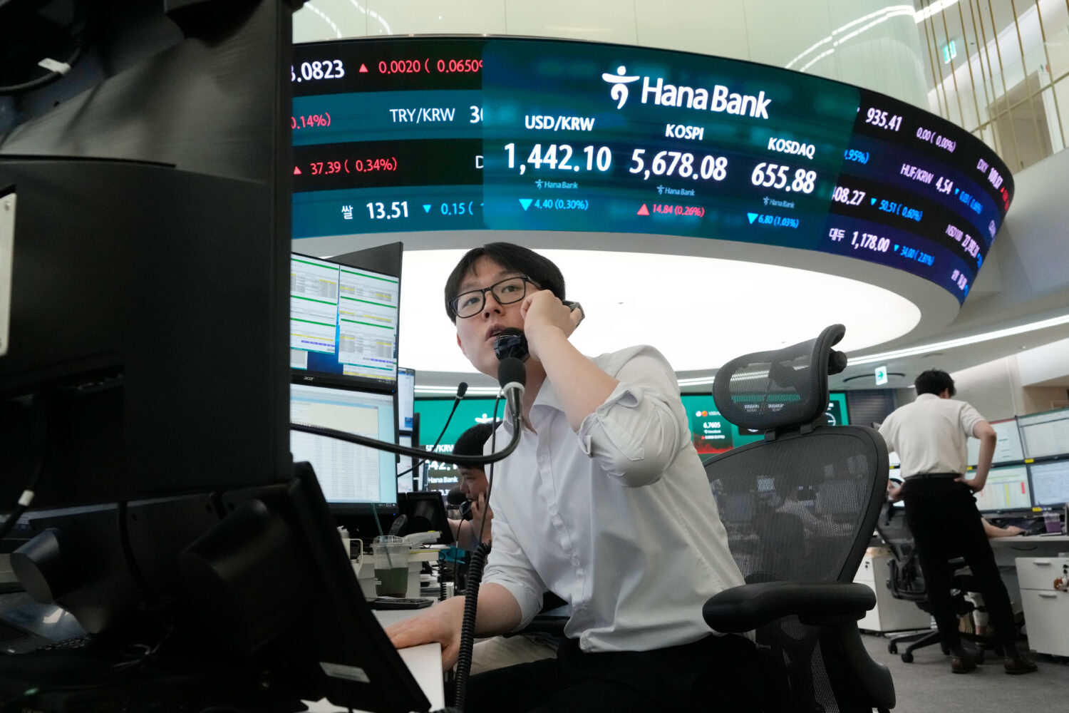 A currency trader talks on the phone at the foreign exchange dealing room of the Hana Bank headquar...