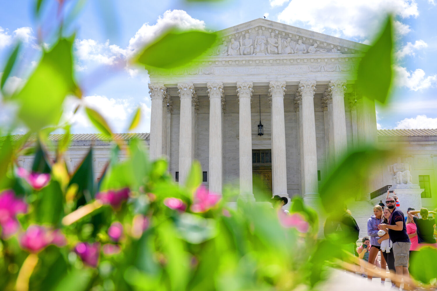 Visitors walk in front of the Supreme Court Friday, July 24, 2026, in Washington. (AP Photo/Mariam ...