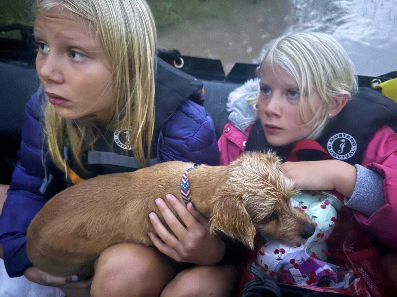 Ella and Grace Sanford and their dog Benjamin ride on a Texas Game Wardens rescue boat after being ...