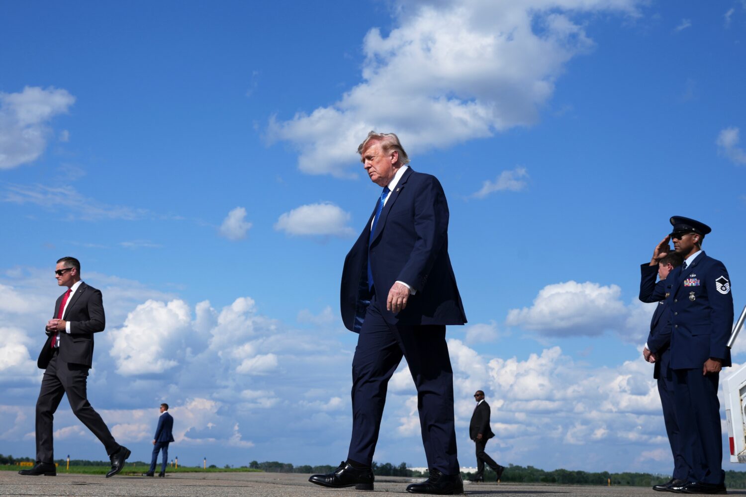 President Donald Trump, center, walks from Air Force One at Morristown Municipal Airport in Morrist...