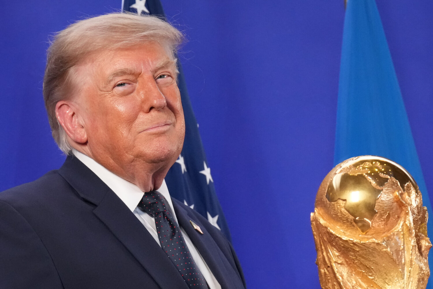 President Donald Trump listens as FIFA President Gianni Infantino speaks at a reception at Trump To...