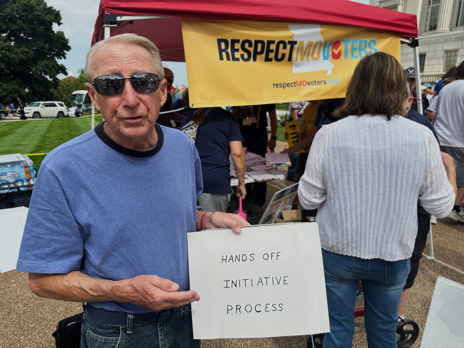 FILE - John Billman, of Columbia, Mo., holds a sign explaining his opposition to a state legislativ...