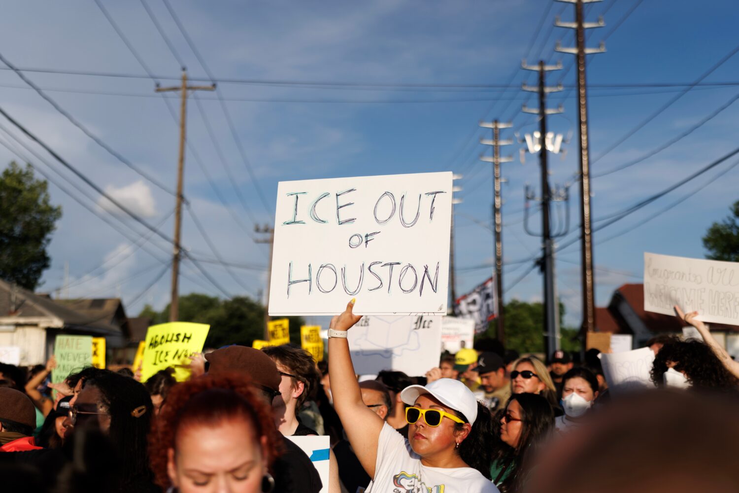 A woman holds a sign reading "ICE OUT OF HOUSTON" during a vigil for Lorenzo Salgado Araujo, a Mexi...