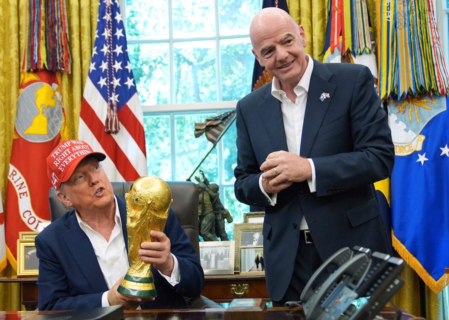 FILE - President Donald Trump holds the FIFA World Cup Winners Trophy as FIFA President Gianni Infa...