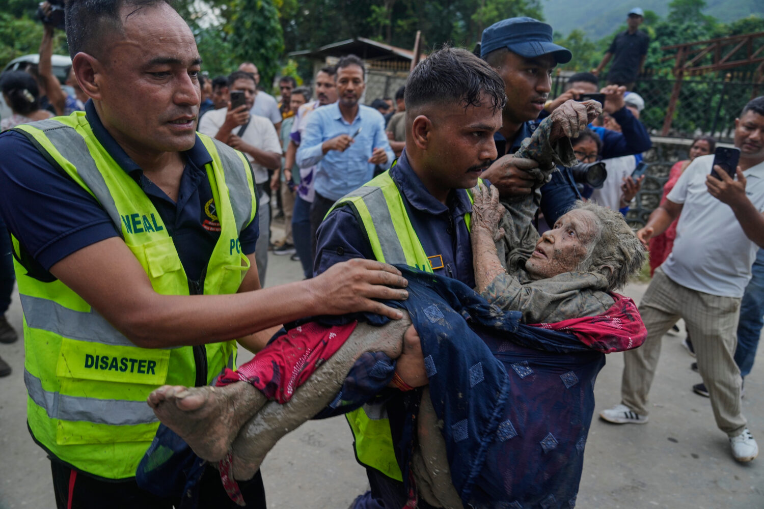 Rescuers carry a victim of flash flooding to safety along the Trishuli River in Nepal's Nuwakot dis...