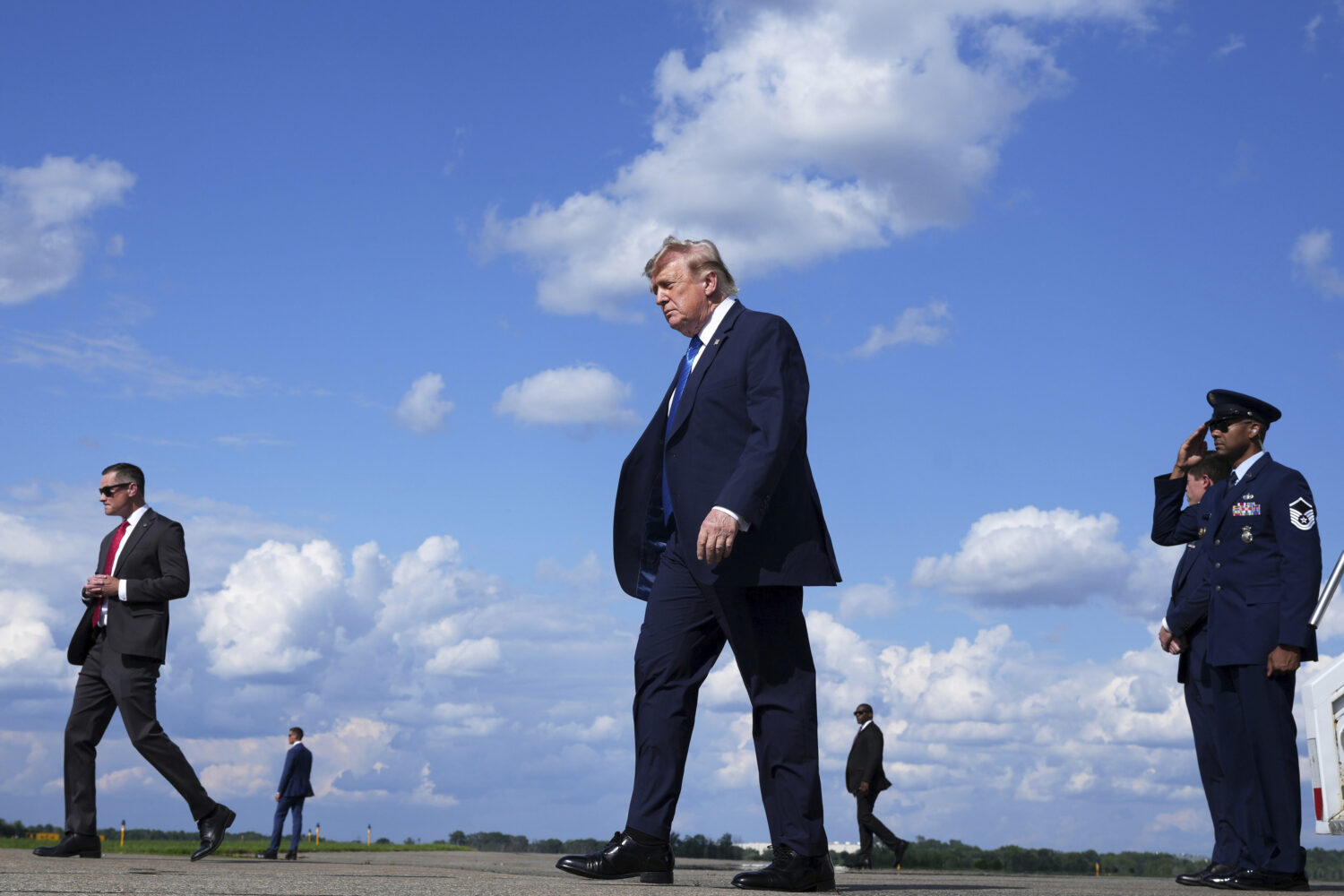 President Donald Trump, center, walks from Air Force One at Morristown Municipal Airport in Morrist...