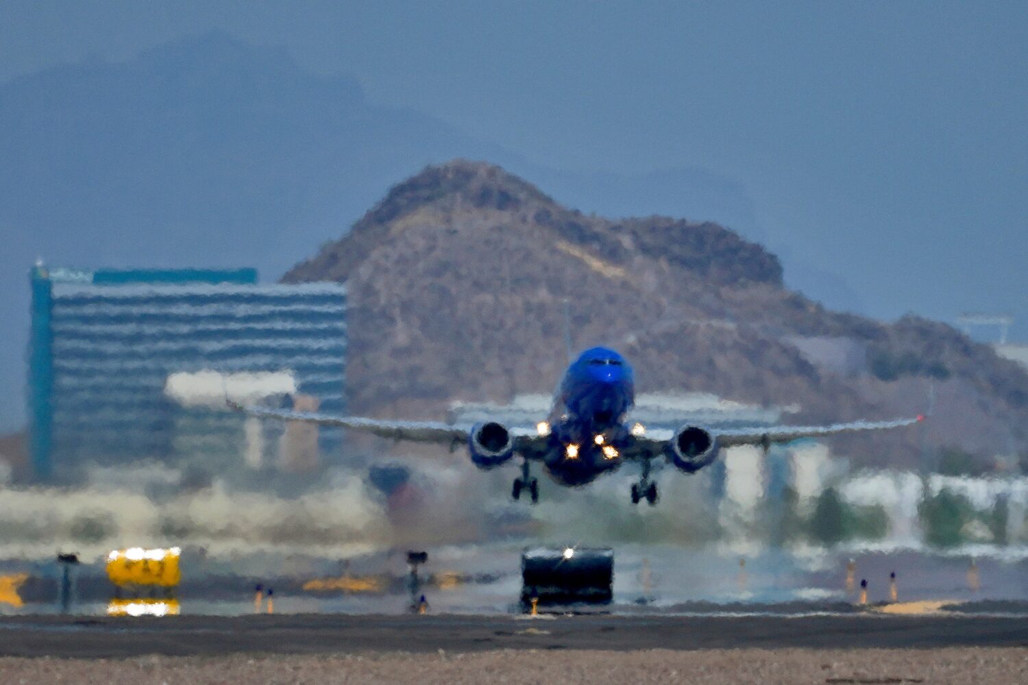 FILE - A jet takes flight as heat ripples radiate from the runway at Sky Harbor International Airpo...